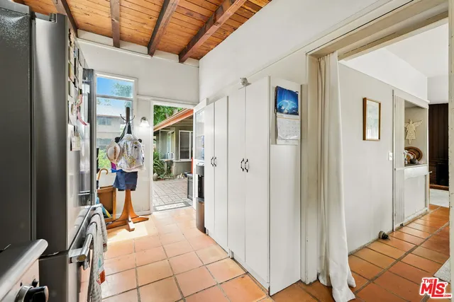 a patio with table and chairs and potted plants