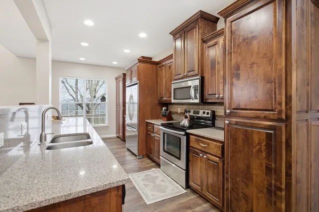 a kitchen with stainless steel appliances granite countertop a sink stove and refrigerator