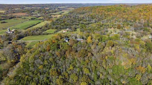 an aerial view of residential houses with outdoor space and trees