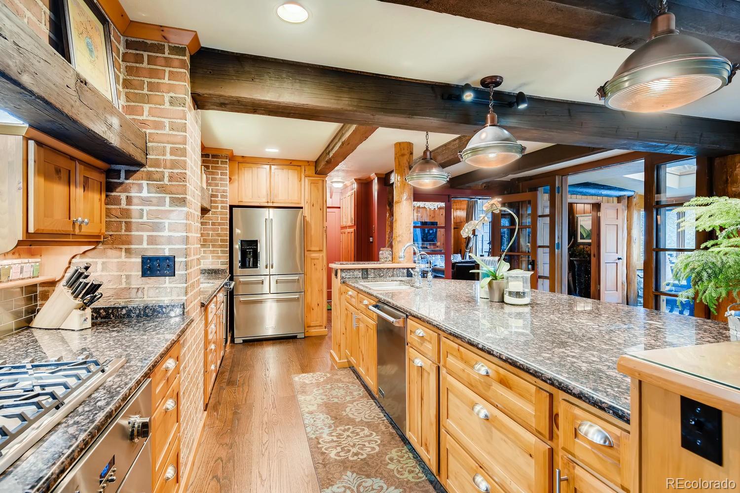 30403 Upper Bear Creek Road Evergreen, CO 80439 - Photo 15 of 40 a kitchen with stainless steel appliances granite countertop sink stove and refrigerator