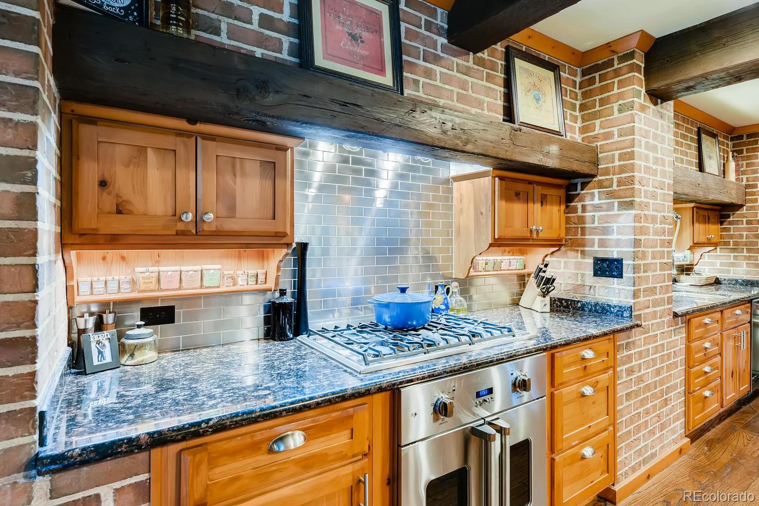 30403 Upper Bear Creek Road Evergreen, CO 80439 - Photo 16 of 40 a kitchen with stainless steel appliances granite countertop a sink a stove and a microwave oven