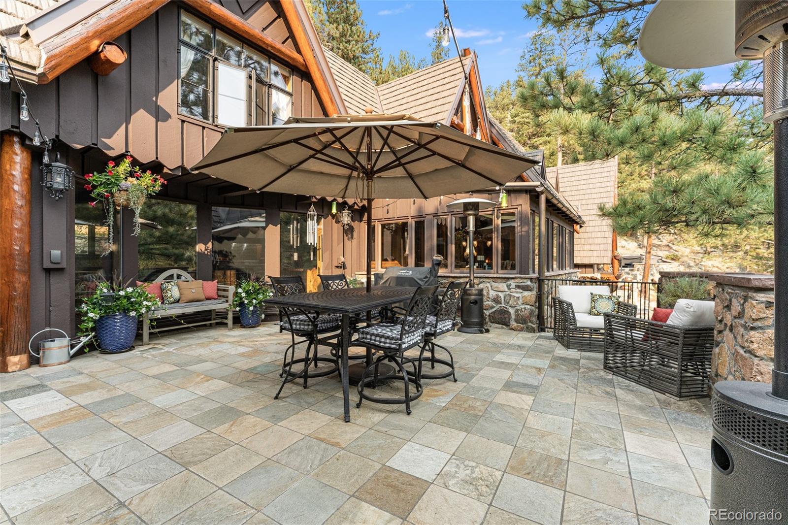 30403 Upper Bear Creek Road Evergreen, CO 80439 - Photo 19 of 40 a view of a patio with table and chairs under an umbrella