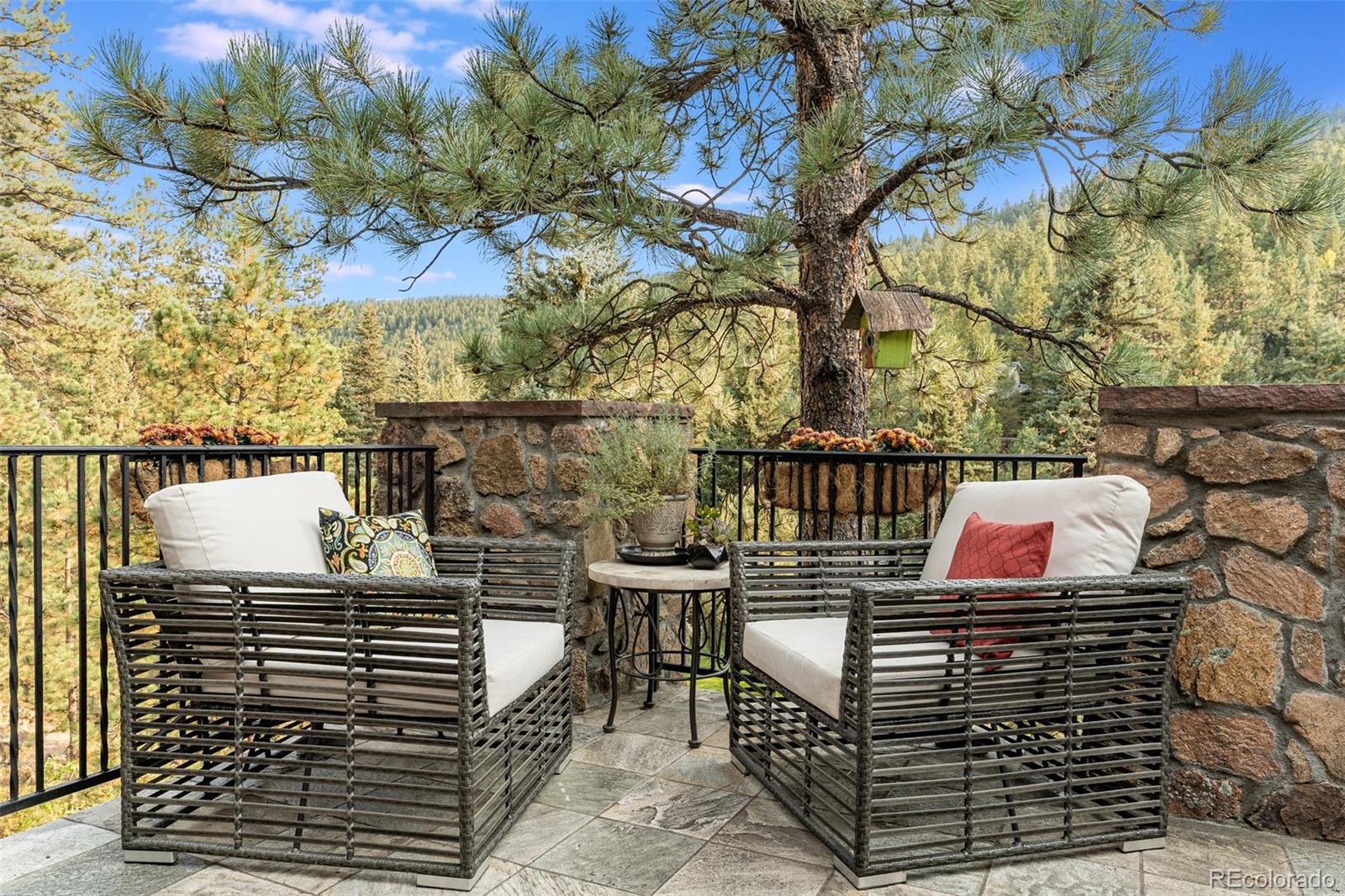 30403 Upper Bear Creek Road Evergreen, CO 80439 - Photo 20 of 40 a balcony with a bench and trees