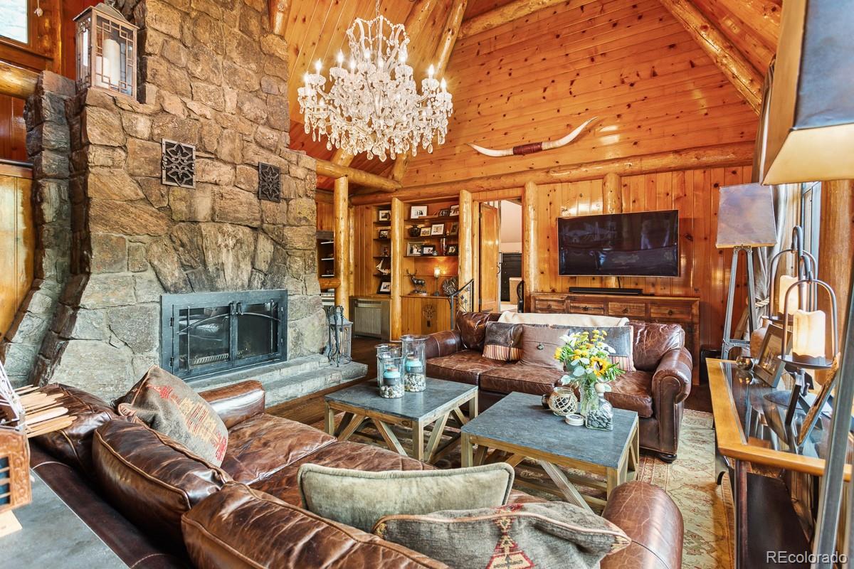 30403 Upper Bear Creek Road Evergreen, CO 80439 - Photo 21 of 40 a view of a patio with couches chairs and a fireplace