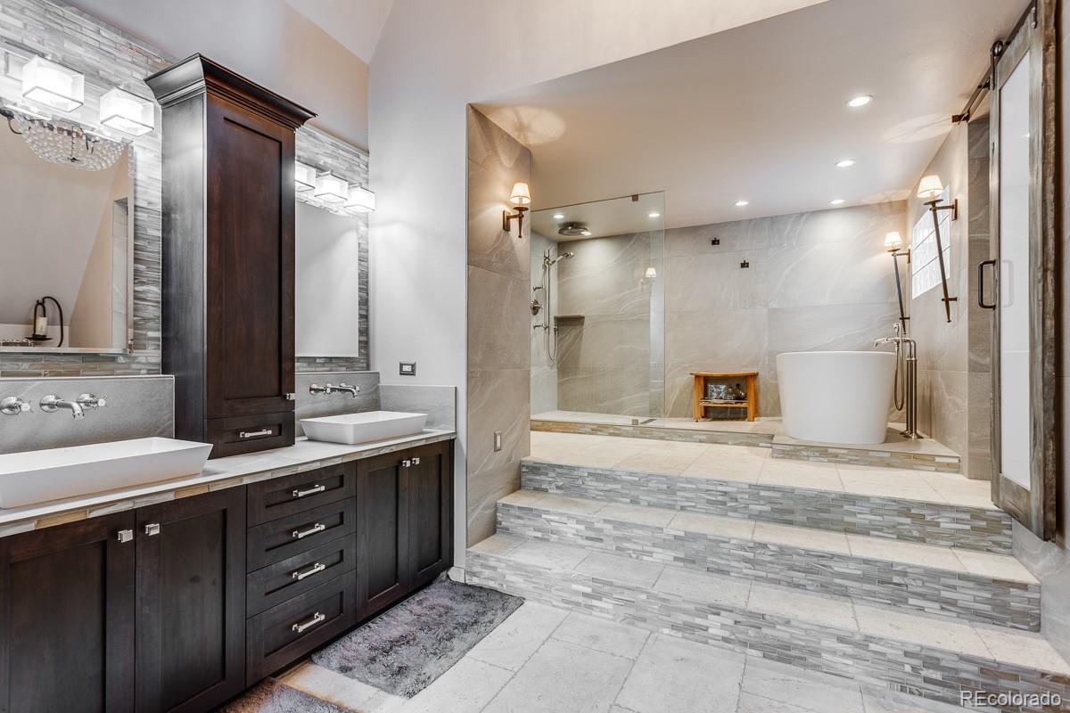 30403 Upper Bear Creek Road Evergreen, CO 80439 - Photo 27 of 40 a bathroom with a sink double vanity granite tub shower and a mirror