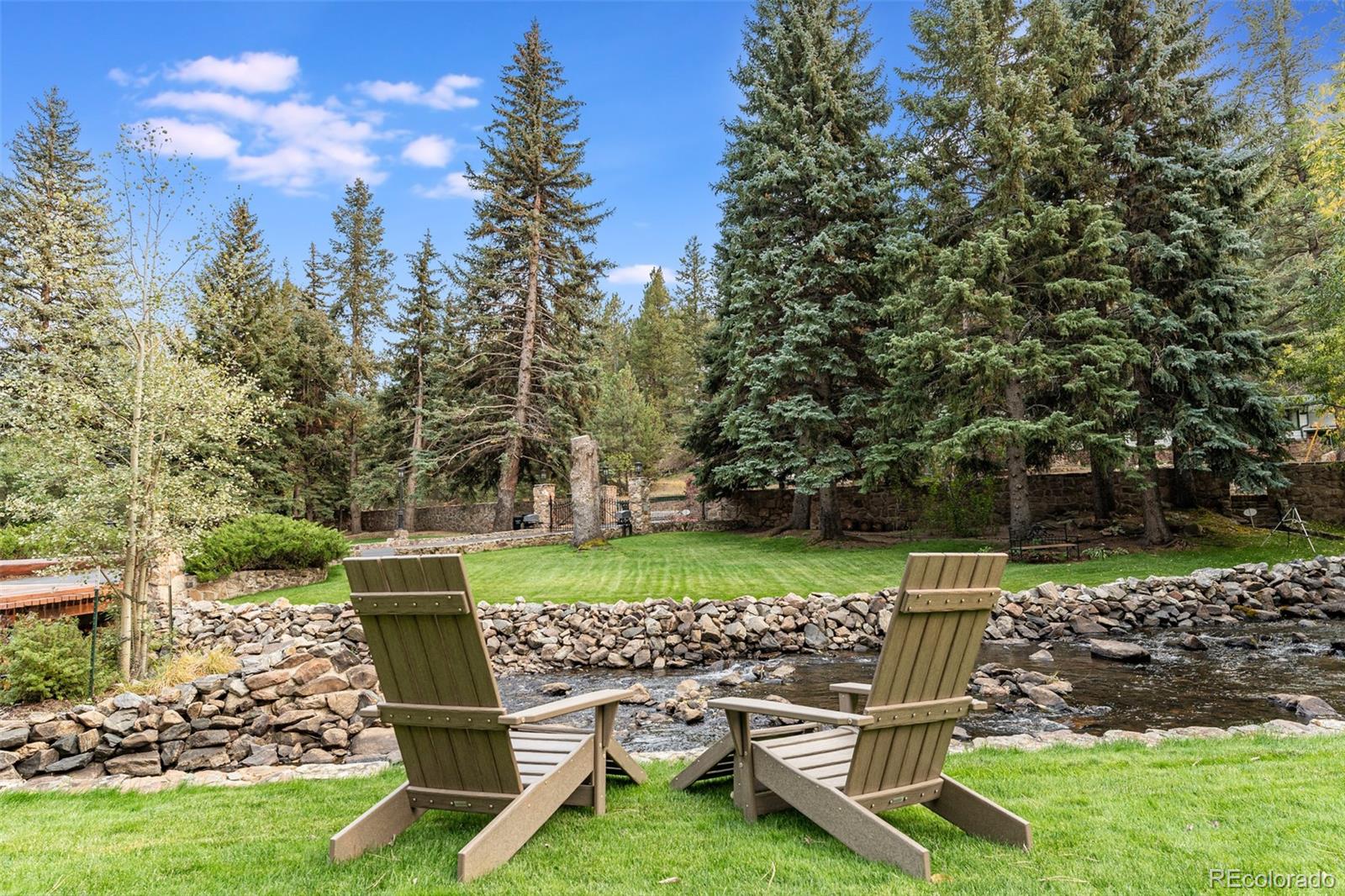 30403 Upper Bear Creek Road Evergreen, CO 80439 - Photo 37 of 40 a view of a chair and table in the garden