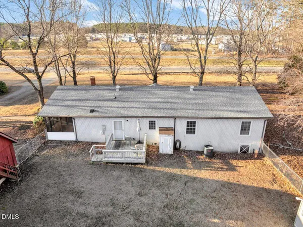 a backyard of a house with table and chairs under an umbrella