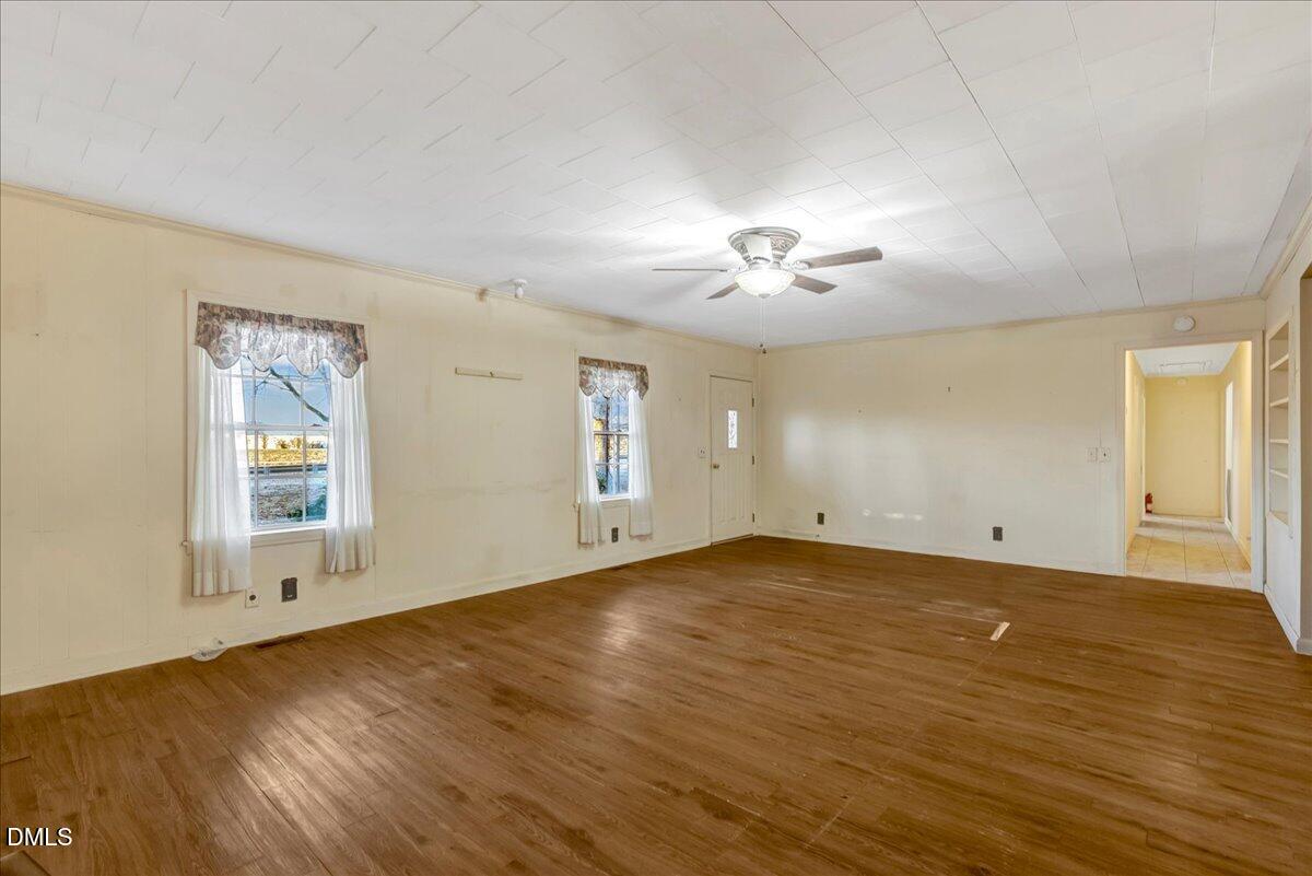 4049 Highway 58 Buffalo Junction, VA 24529 - Photo 9 of 21 an empty room with wooden floor chandelier and windows