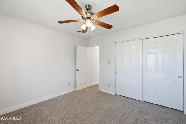 an empty room with windows and fan