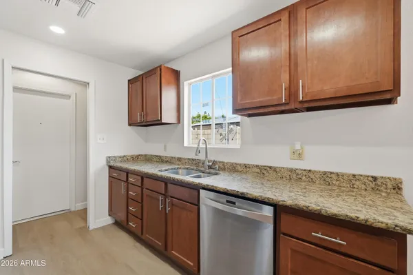 a kitchen with granite countertop cabinets sink and stove