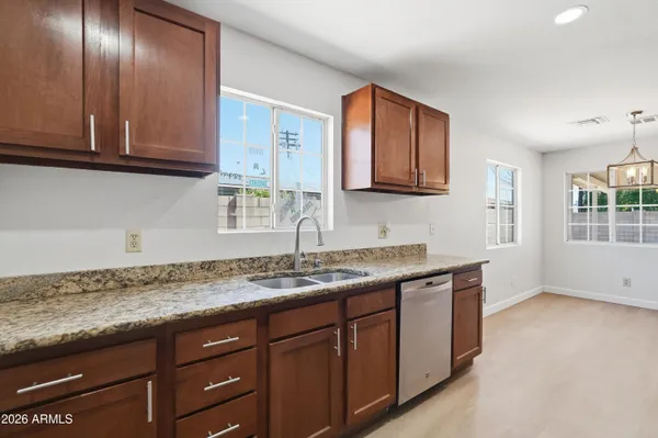 a kitchen with granite countertop stainless steel appliances sink and cabinets