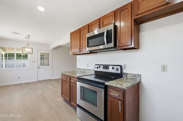 a kitchen with stainless steel appliances granite countertop white cabinets a microwave oven and a sink