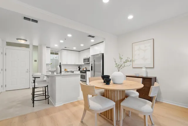 a dining room with kitchen island a sink a stove a dining table and chairs