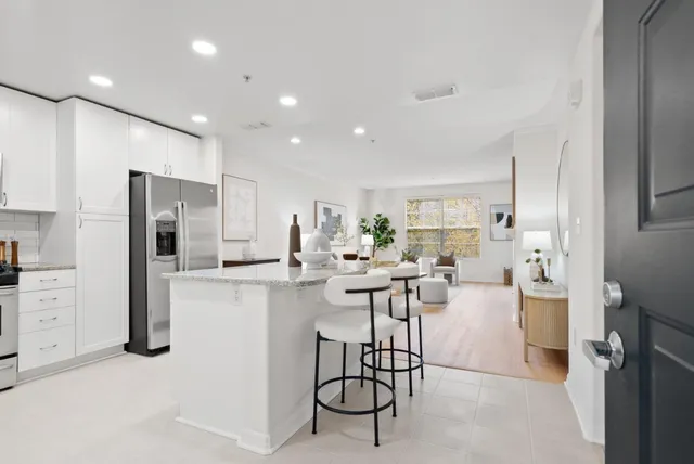 a kitchen with stainless steel appliances kitchen island granite countertop a stove a sink a refrigerator and a microwave