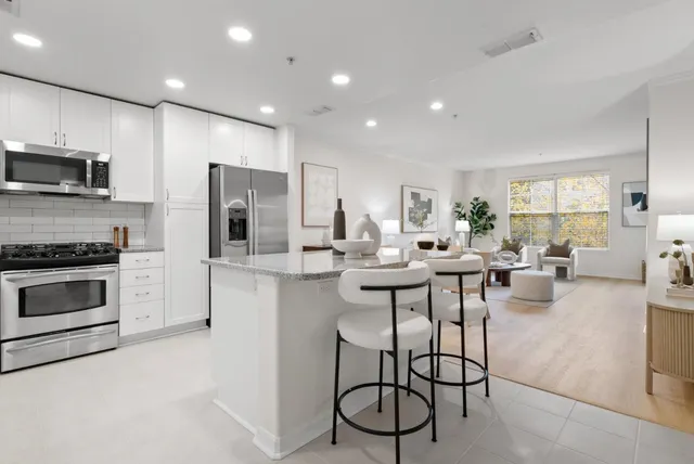 a kitchen with stainless steel appliances kitchen island granite countertop a table and chairs