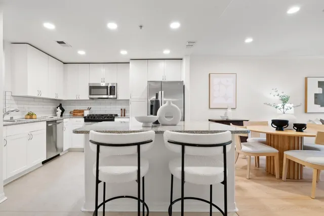 a kitchen with stainless steel appliances granite countertop a sink refrigerator and cabinets