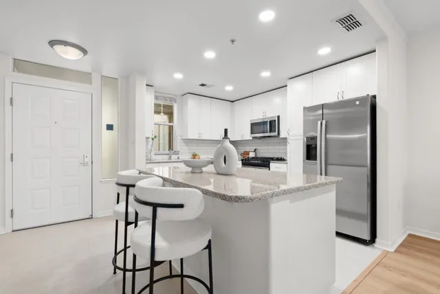 a kitchen with granite countertop white cabinets and white appliances