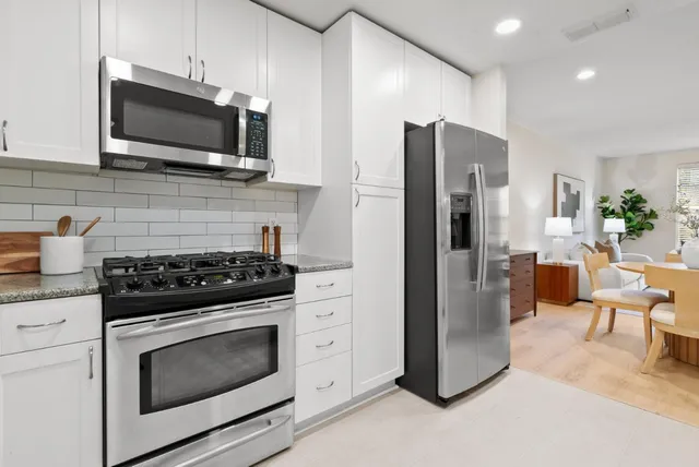 a view of a kitchen with dining area a chandelier and windows
