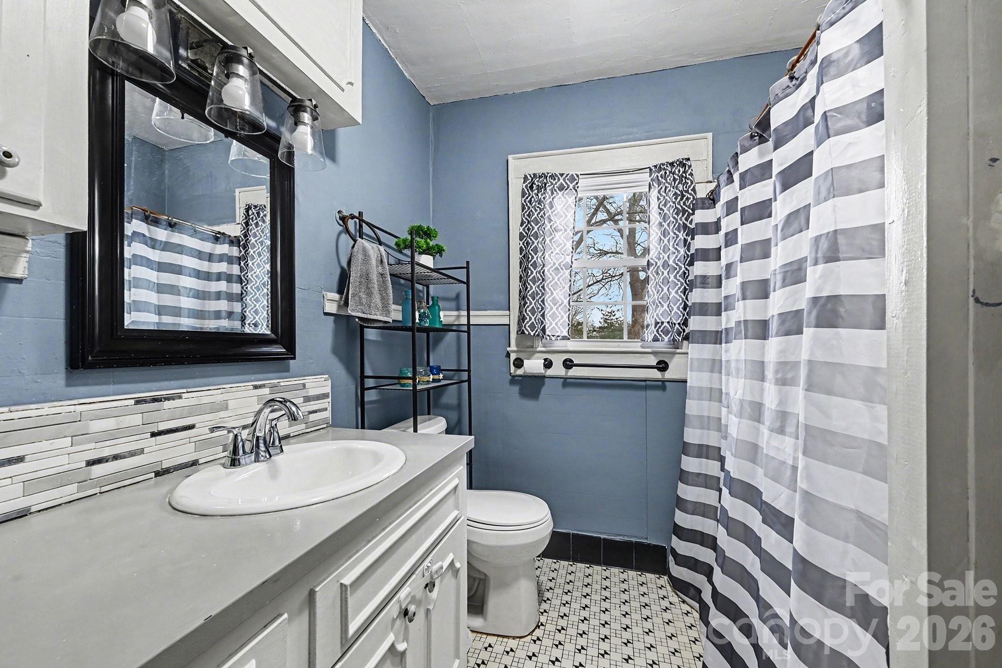 409 Miles Road Shelby, NC 28150 - Photo 14 of 23 a bathroom with a sink a toilet a mirror and shower