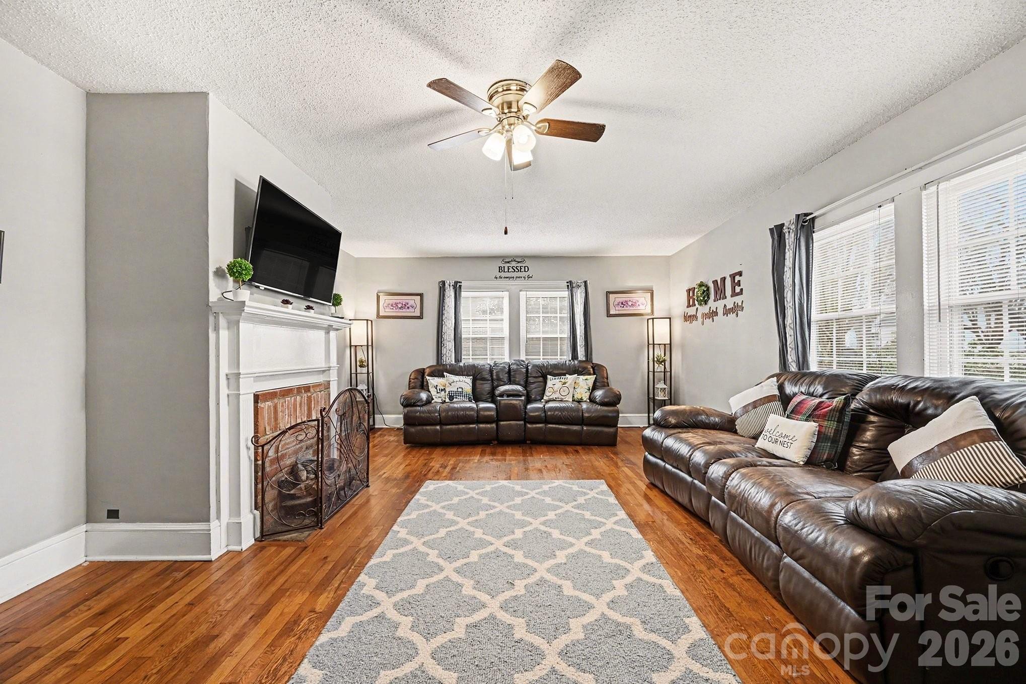 409 Miles Road Shelby, NC 28150 - Photo 7 of 23 a living room with furniture a fireplace and a flat screen tv