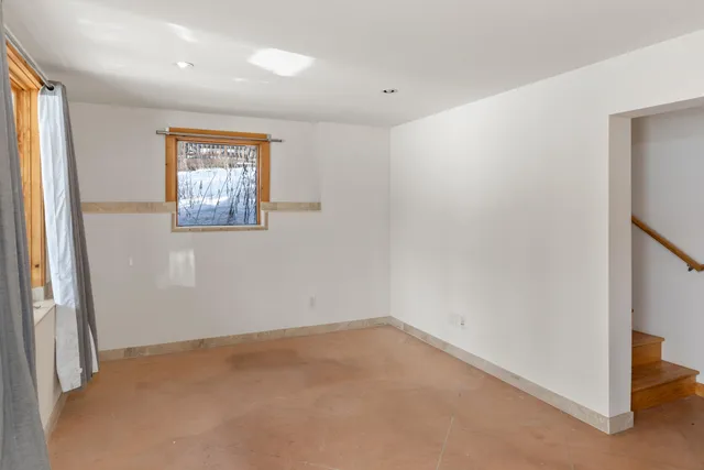 an empty room with projector and windows