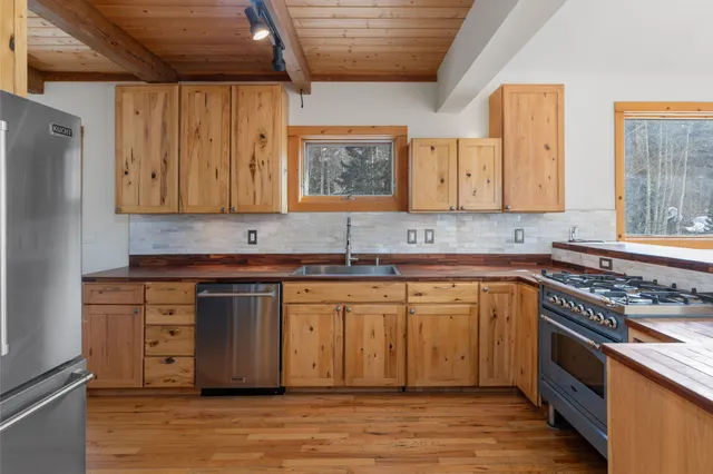 a kitchen with granite countertop a stove cabinets and wooden floor