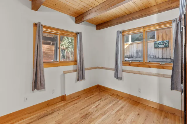 a view of a room with wooden floor and a window