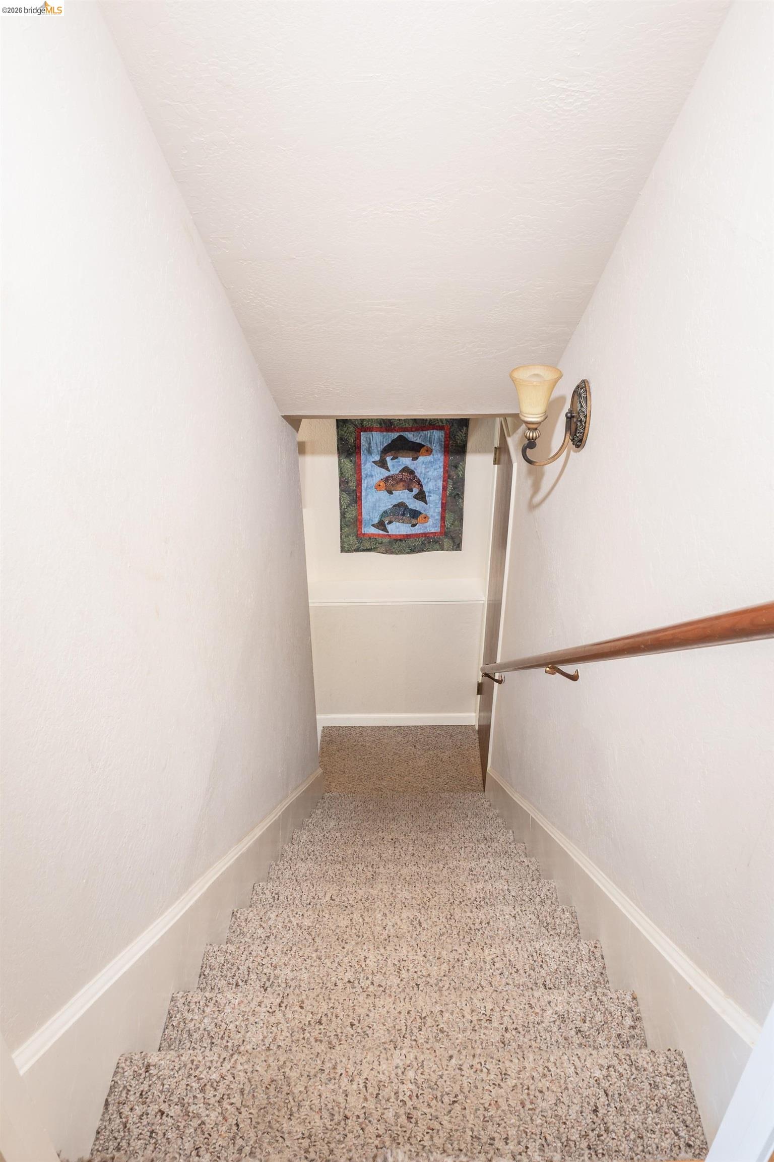 19711 Pleasantview Drive Groveland, CA 95321 - Photo 27 of 39 Carpeted stairway featuring a wooden handrail, wall sconce, and white baseboards