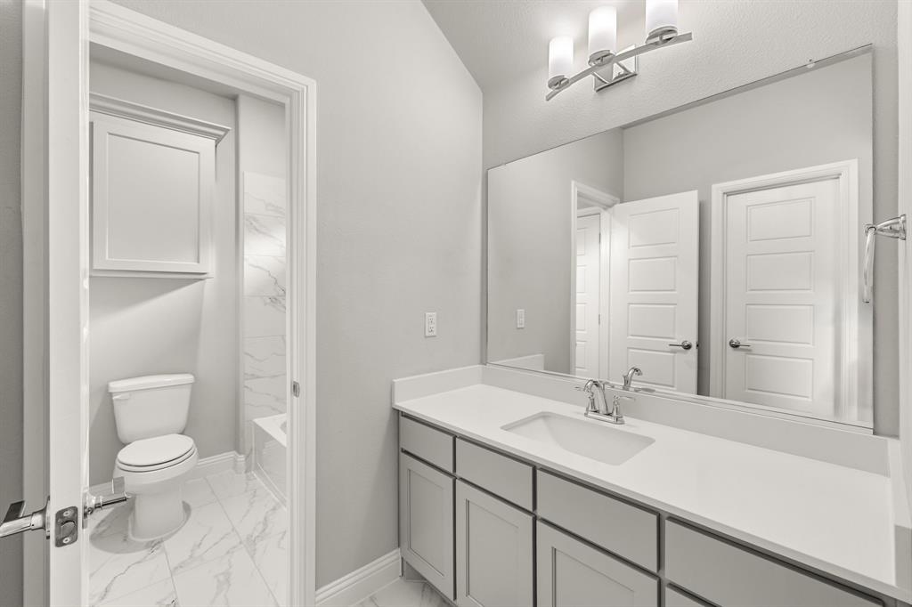 7852 Buffaloberry Road Frisco, TX 75035 - Photo 28 of 36 Bathroom featuring a single vanity with light grey cabinetry, a white countertop, and an undermount sink