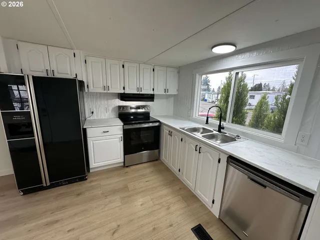 a kitchen with stainless steel appliances a sink stove and refrigerator