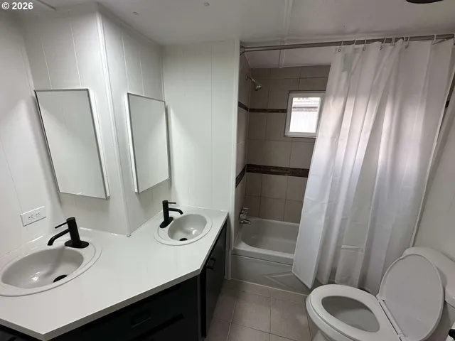 a bathroom with a sink a toilet and shower a mirror