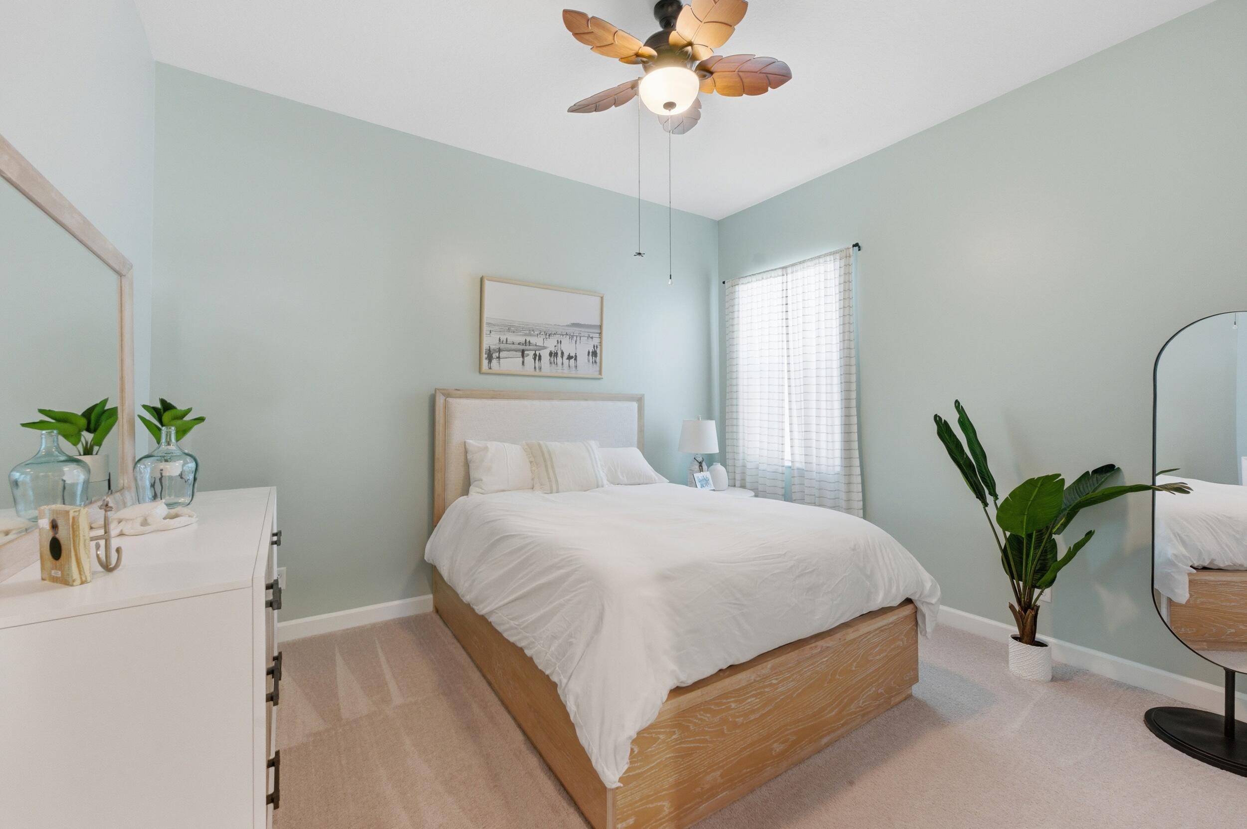 19230 Rolling Acres Road Loxahatchee, FL 33470 - Photo 18 of 58 a bedroom with a bed and a potted plant