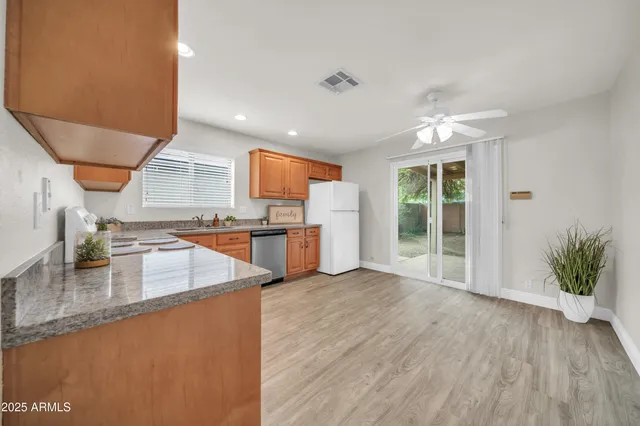 a kitchen with a refrigerator a sink dishwasher with a dining table and chairs