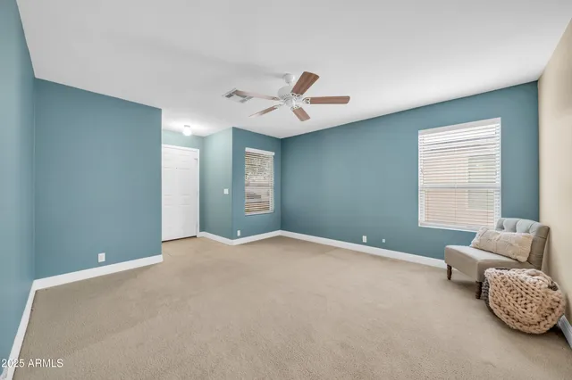 an empty room with a ceiling fan and a window