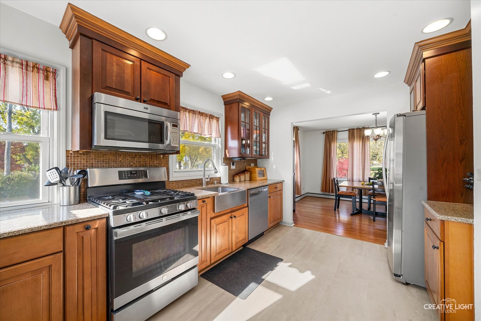 457 West Spring Street South Elgin, IL 60177 - Photo 4 of 21 a kitchen with stainless steel appliances granite countertop a stove top oven a sink dishwasher a dining table and chairs with wooden floor