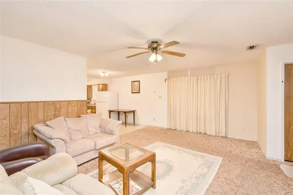 a living room with furniture and a ceiling fan