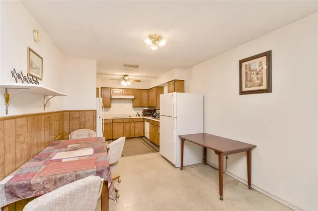 a living room with furniture a refrigerator and kitchen view