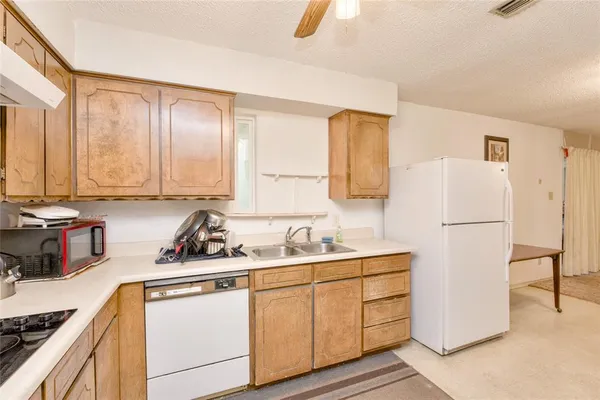 a kitchen with a sink a refrigerator and cabinets
