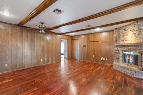 a view of a livingroom with a ceiling fan and wooden floor