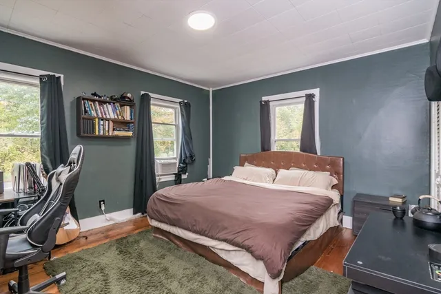 a bedroom with a bed window and two windows