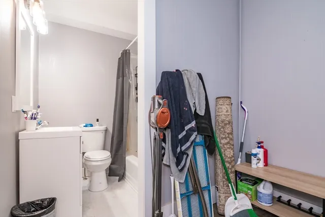 a bathroom with a toilet a sink and a shower curtain