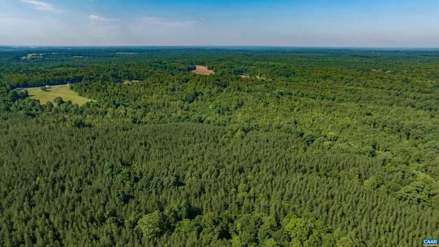 an aerial view of residential houses with outdoor space and trees