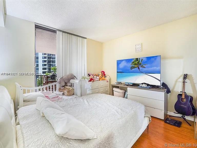 540 Brickell Key Drive, Unit 603 Miami, FL 33131 - Photo 11 of 18 a bedroom with furniture and a flat screen tv