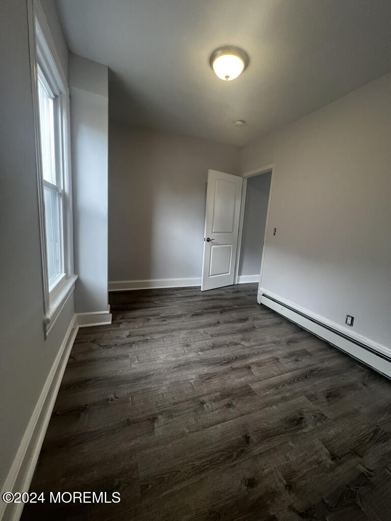 615 2nd Avenue, Unit 1 Asbury Park, NJ 07712 - Photo 19 of 39 an empty room with wooden floor and windows