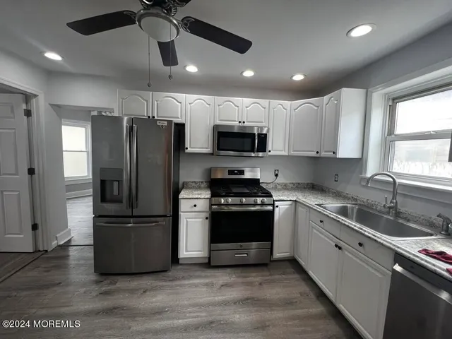 a kitchen with stainless steel appliances a refrigerator sink and microwave