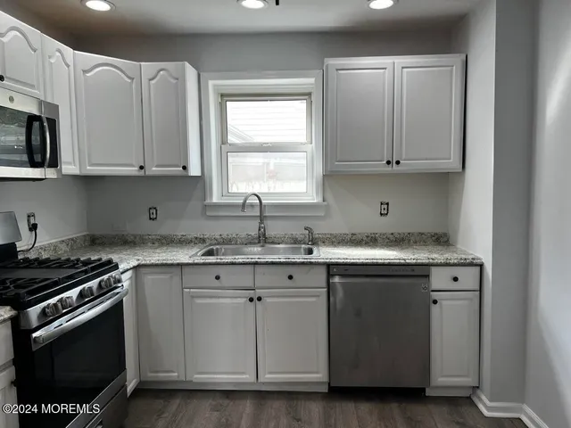 a kitchen with stainless steel appliances granite countertop a sink stove and microwave