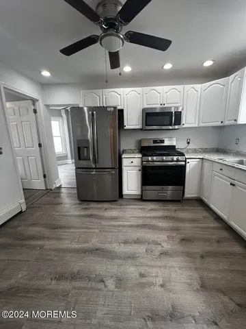 a kitchen with stainless steel appliances granite countertop a refrigerator a stove a sink and a microwave