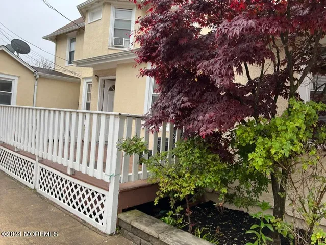a view of a yard with plants and wooden fence
