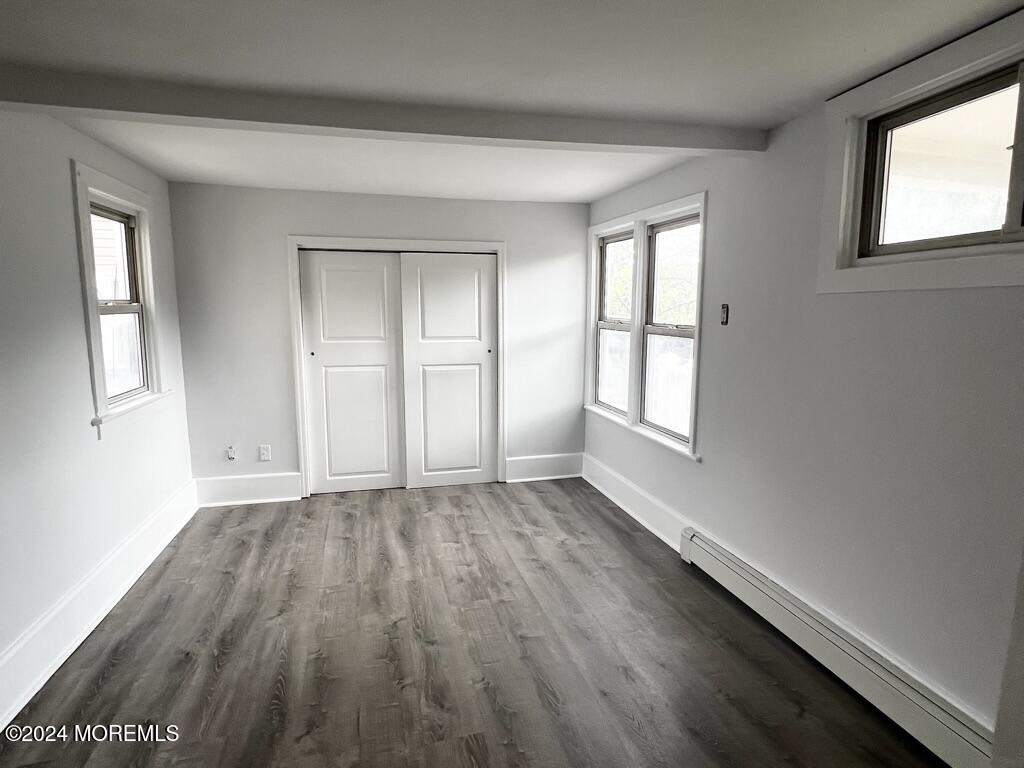 615 2nd Avenue, Unit 1 Asbury Park, NJ 07712 - Photo 9 of 39 an empty room with wooden floor and windows