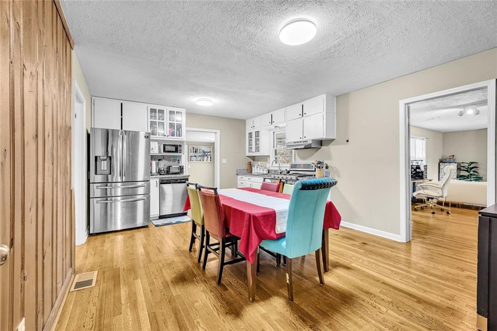 349 Virginia Place Southeast Marietta, GA 30067 - Photo 13 of 37 a kitchen with stainless steel appliances a dining table chairs and refrigerator